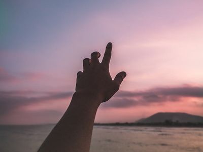 Silhouette of a person stretching at sunrise.